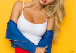 Blonde woman in white tanktop and blue sweater