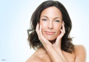 Woman holding face in hands with black hair