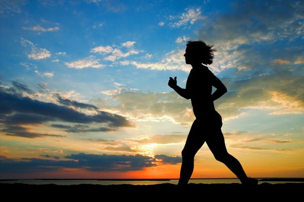 Woman running on water at sunset