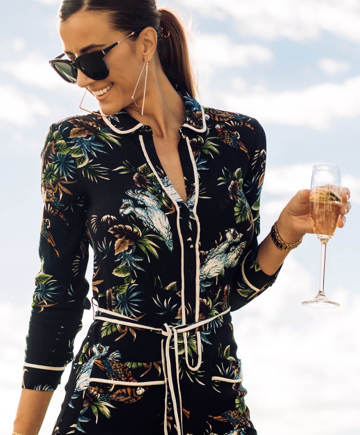 Liposuction patient model in a fashionable outfit holding a glass of wine