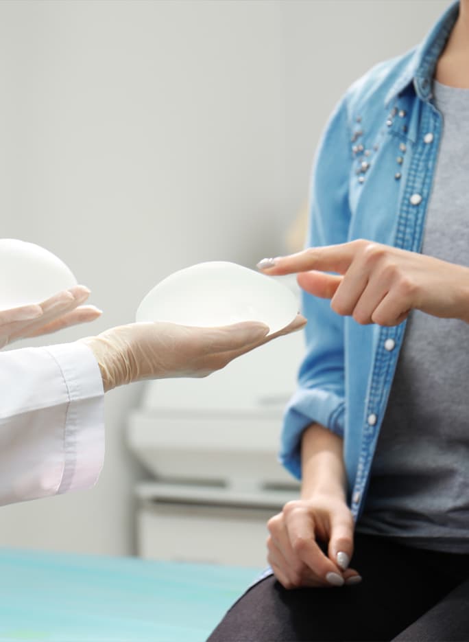 plastic surgeon showing a patient model a textured breast implant